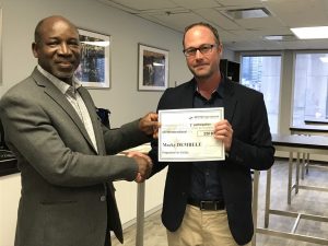 Photo d'un membre recevant son certificat cadeau grâce au programme de fidélité, pendant la formation sur la Certification en leadership et habiletés de direction